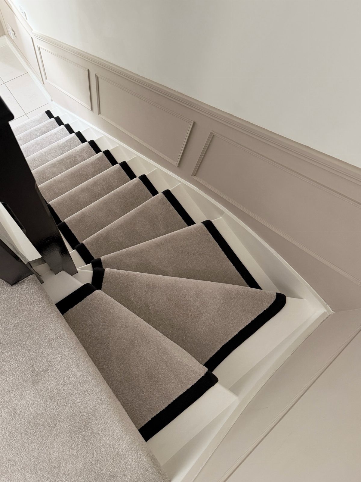 Stairs with Carpet: 23 Styles from Runners to Bold Patterns 9 Grey carpet runner with black borders on white painted wooden stairs.