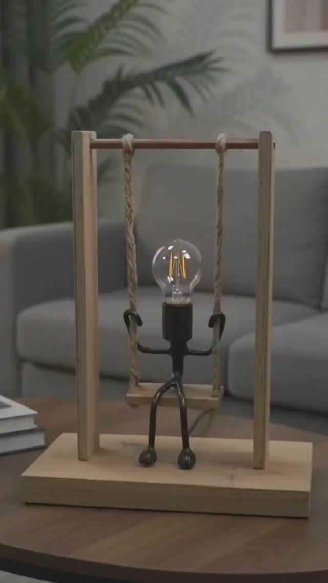 17 Handmade Lamps Ideas Using Wood, Concrete, and Glass Jars 1 Stick-figure person holding a glowing light bulb on a wooden swing lamp.