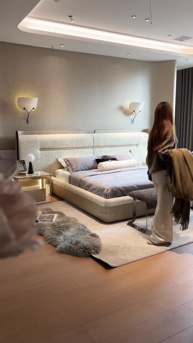 22 Bedroom Empty Wall Ideas, from Gallery Walls to Plaster 12 Modern bedroom with a neutral grey wall, upholstered headboard, and wall sconces.