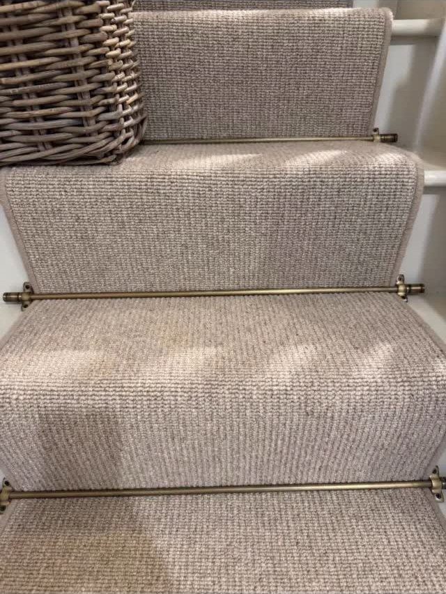 Stairs with Carpet: 23 Styles from Runners to Bold Patterns 5 Beige textured sisal carpet on stairs with decorative brass stair rods and wicker basket.
