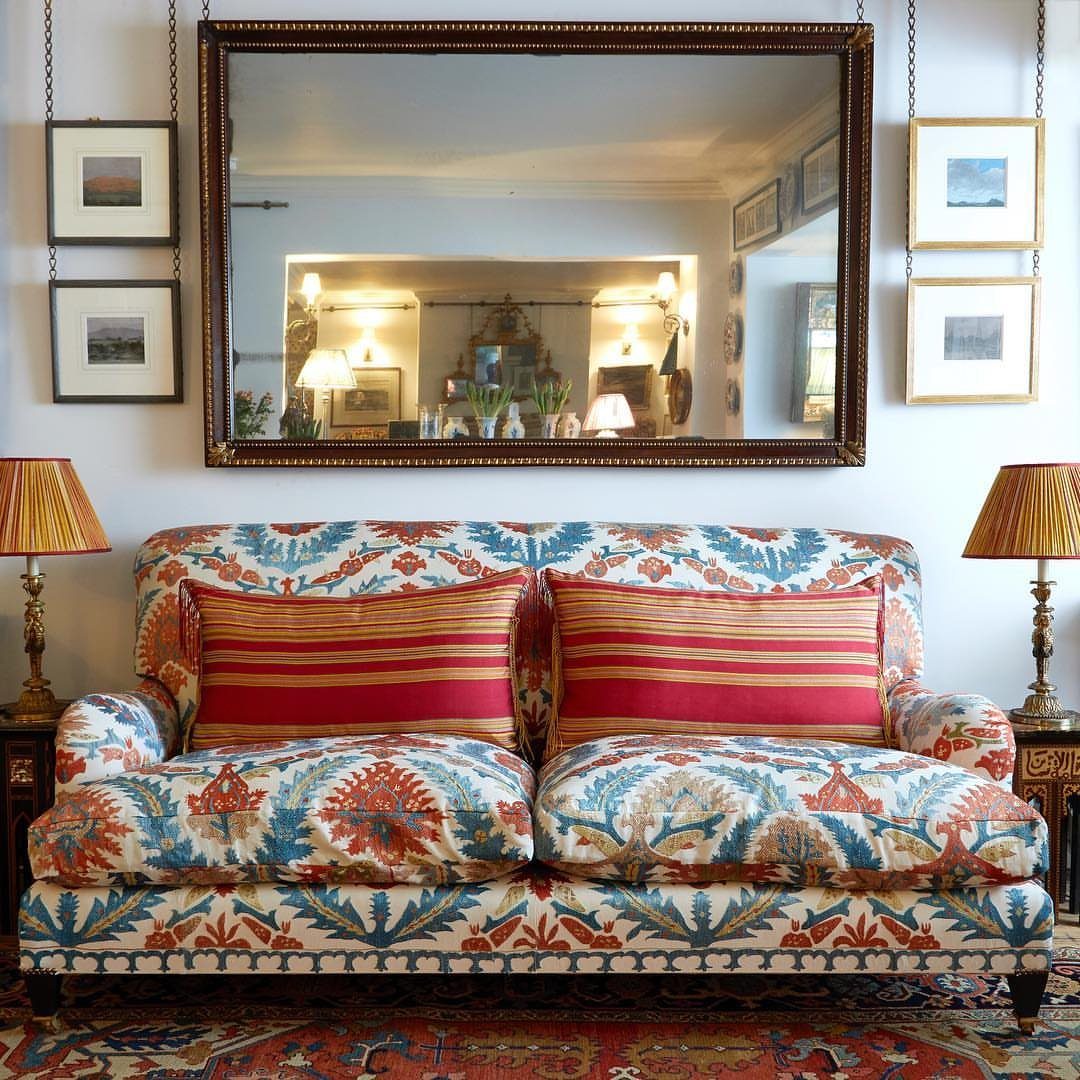 Mirror Wall Art: 25 Ideas from Sunburst to Floor Mirrors 20 Rectangular gold framed mirror hanging on a wall above a patterned sofa.