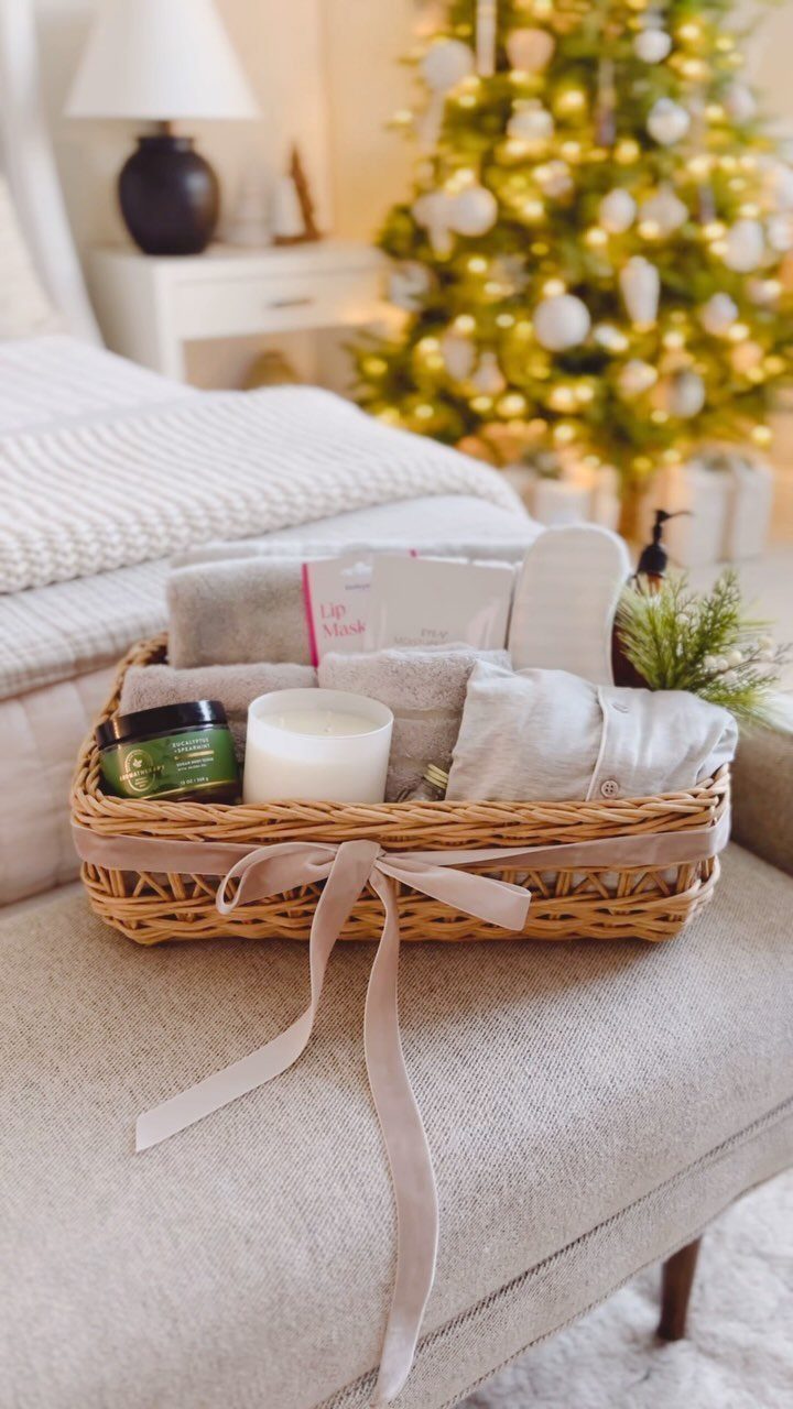 Wicker gift basket with spa products, towels, and slippers in a cozy room.