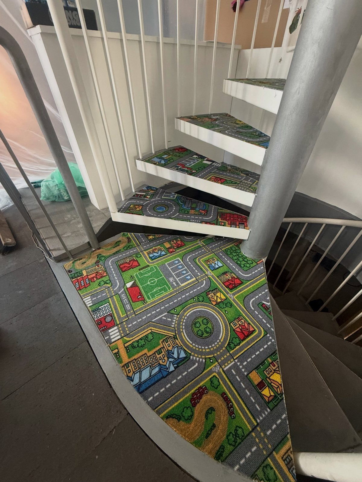 Stairs with Carpet: 23 Styles from Runners to Bold Patterns 20 Spiral staircase with colorful city map patterned carpet on each step.