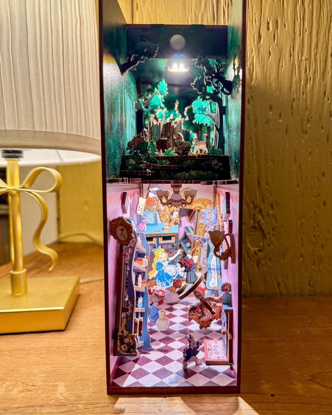 Alice in Wonderland themed miniature book nook diorama with checkered floor and tiny figures
