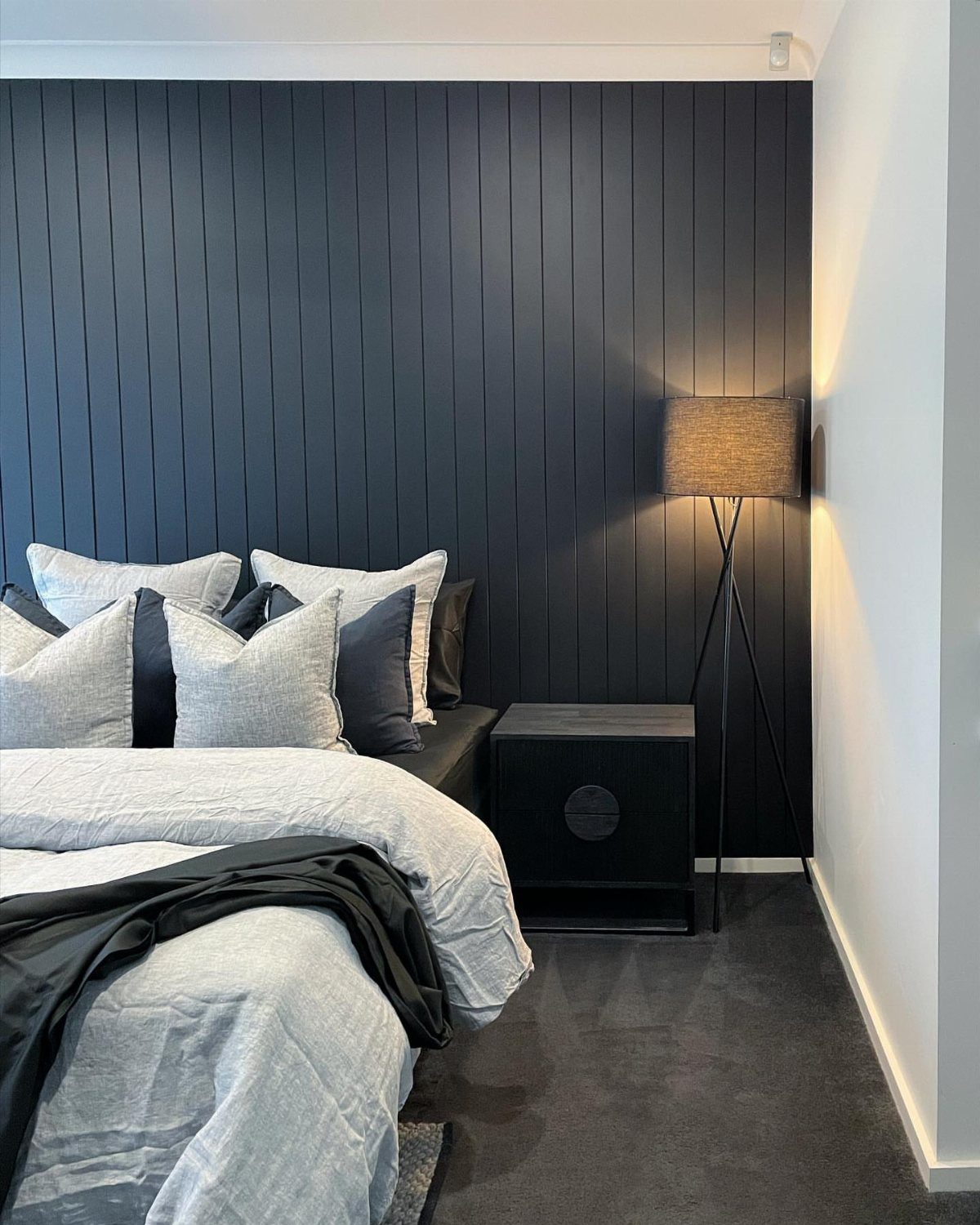 22 Bedroom Empty Wall Ideas, from Gallery Walls to Plaster 11 Dark grey vertical slatted feature wall in a modern bedroom with grey bedding.