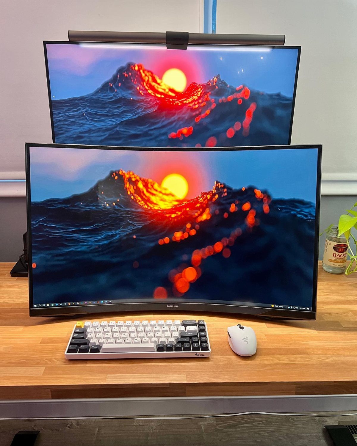 13 Double Monitor Desk Setup Aesthetic Ideas That Work 3 Two vertically stacked monitors displaying ocean sunset wallpaper on a light wood desk.