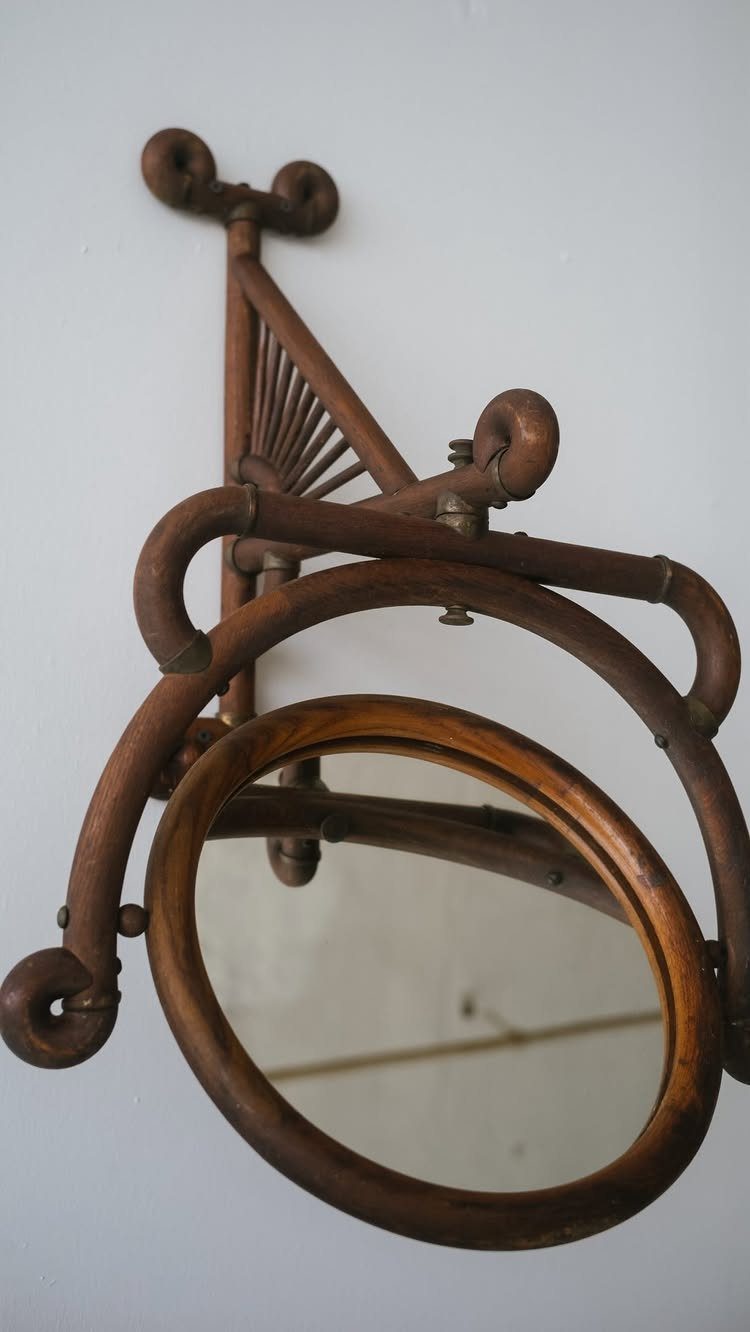Mirror Wall Art: 25 Ideas from Sunburst to Floor Mirrors 12 Oval wooden mirror integrated into an ornate, curved brown wooden wall sculpture.