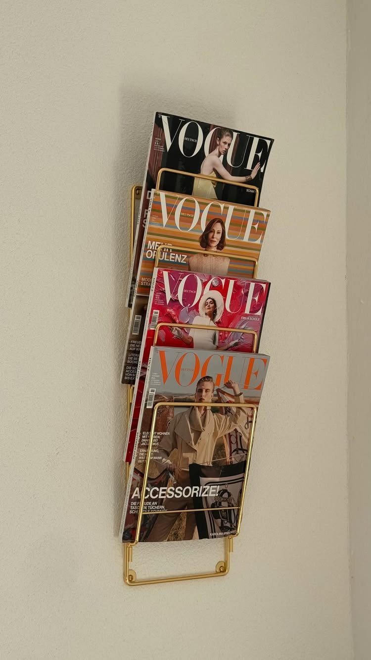 23 Cool House Items for Walls, Shelves, Desks, and Baths 22 Gold metal wall magazine rack holding several Vogue magazines on a white wall.