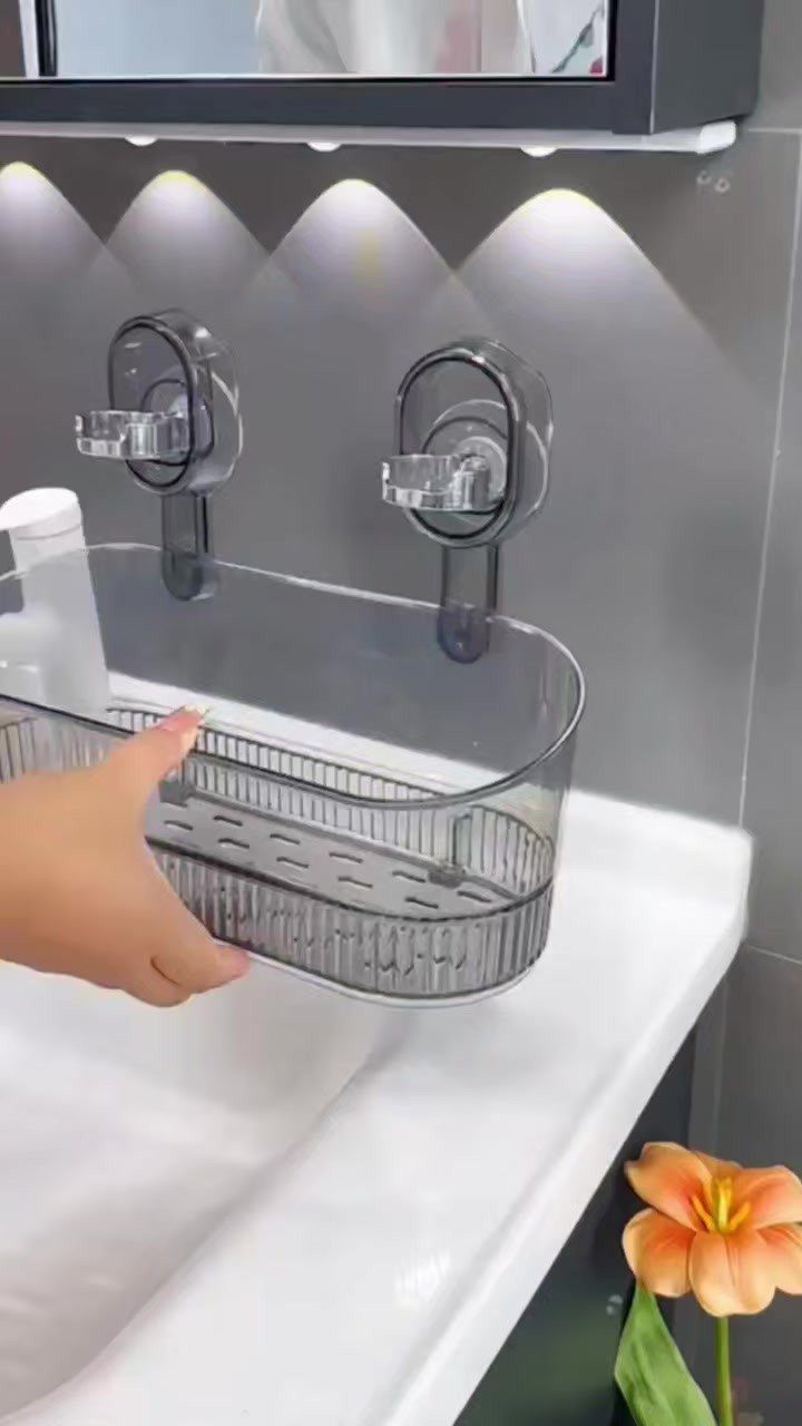 Bathroom Shelf Unit Ideas: 28 Storage and Display Options 16 Grey plastic wall-mounted organizer with suction hooks holding a bottle above a white sink.