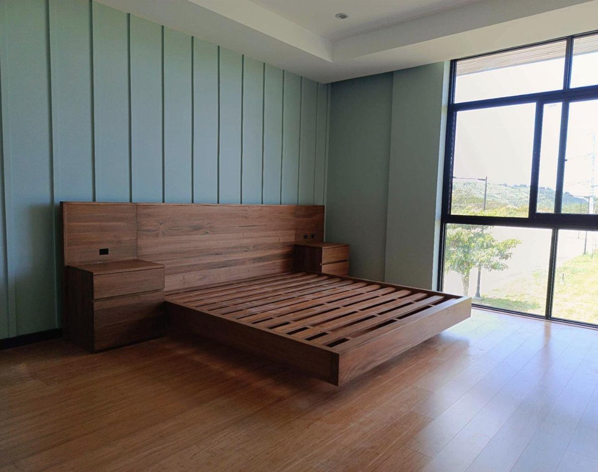 22 Bedroom Empty Wall Ideas, from Gallery Walls to Plaster 5 Wooden platform bed with integrated headboard against a light blue paneled wall.