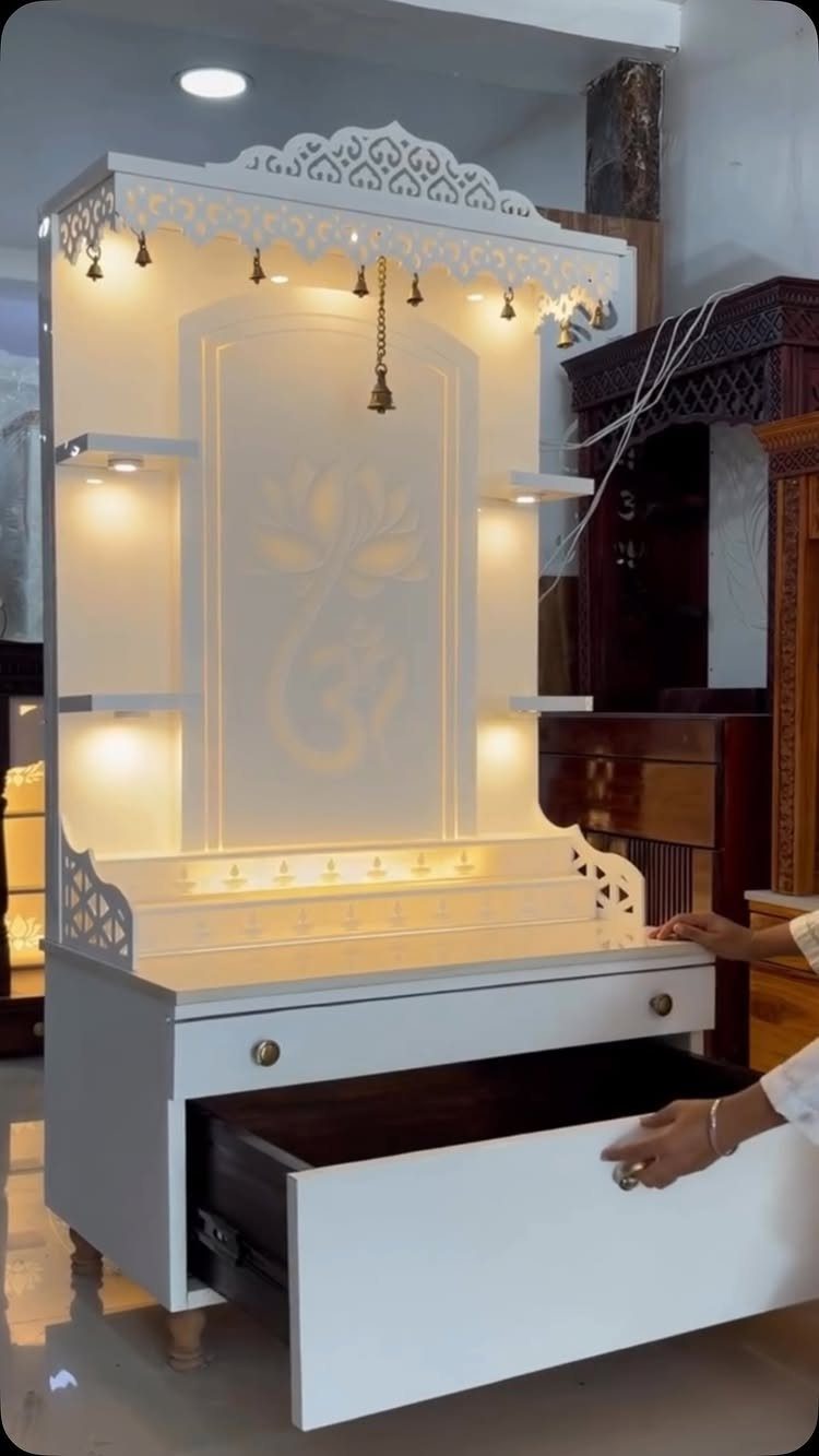 34 Puja Unit Design Modern Ideas for Your Home in 2026 18 White wooden pooja unit with backlit Om symbol and carved decorative top.
