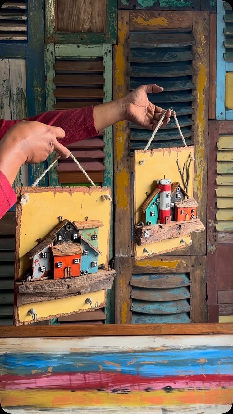 Wood Art Wall Decor: 28 Ideas, From Carved Panels to Mirrors 25 Miniature colorful houses on wooden plaques with natural branch bases held by hands.