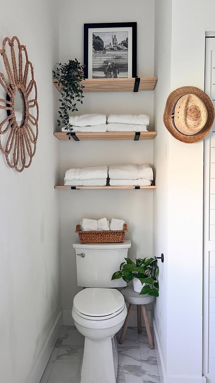 Bathroom Shelf Unit Ideas: 28 Storage and Display Options 8 Wooden floating shelves with black metal brackets holding white towels above a toilet.