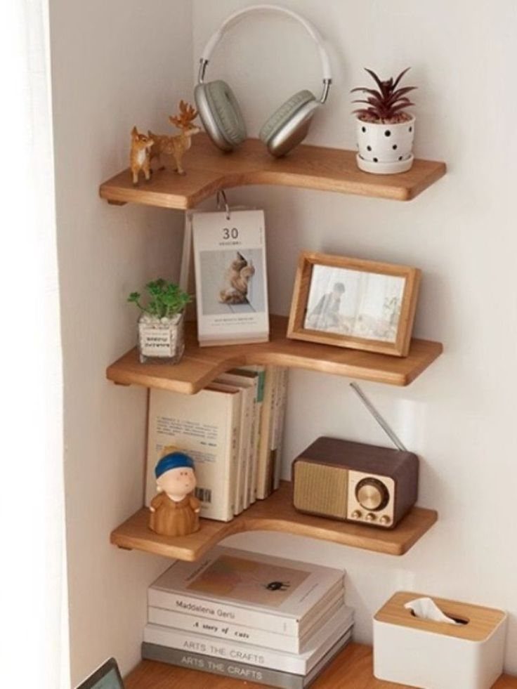 24 Corner Shelves IKEA Ideas for Kitchens, TVs and Plants 20 Three wooden corner shelves holding books, a radio, and decorative items on white walls.