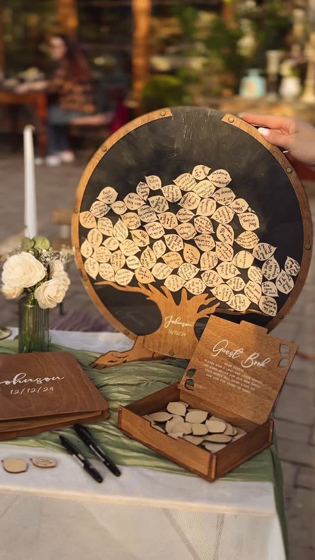 Wooden tree guest book with leaf tokens and matching box on a wedding table