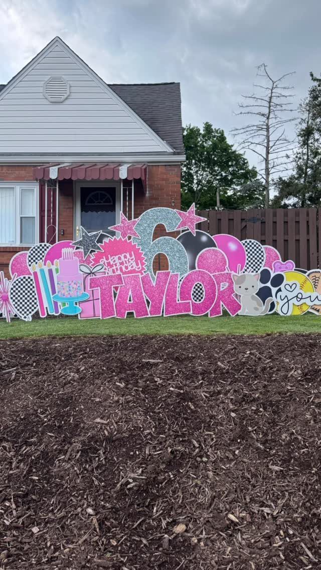 Colorful glittery yard signs spelling Taylor and the number 6 in a garden.