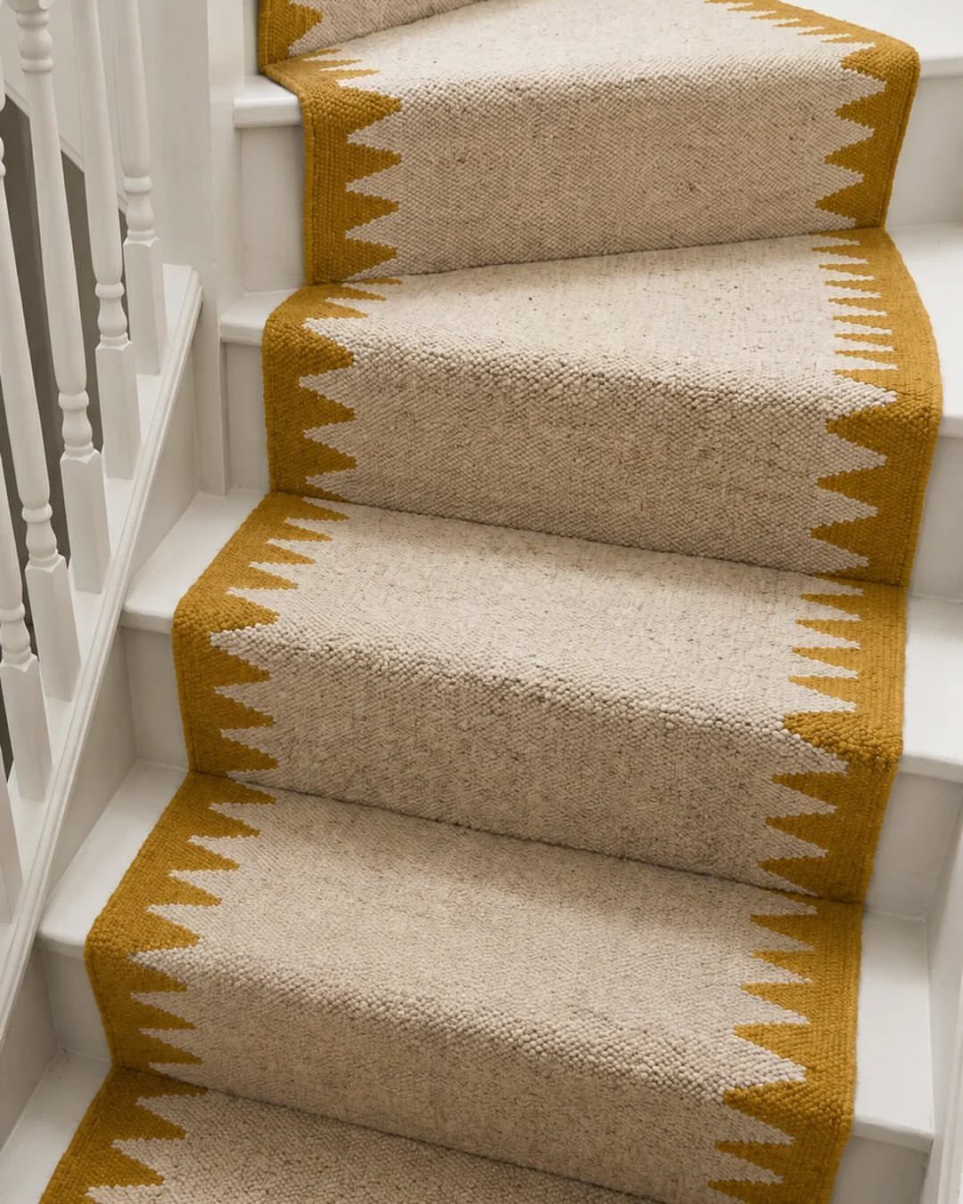 Stairs with Carpet: 23 Styles from Runners to Bold Patterns 22 Beige carpet runner with yellow zigzag borders on white wooden stairs.
